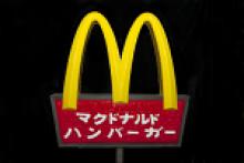 Japanese McDonald's sign with yellow arches and red signage with Japanese letters