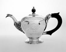 Silver teapot with etching and black handle